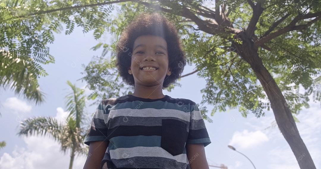 Retrato fofo ao ar livre de um menino afro-americano sorridente.