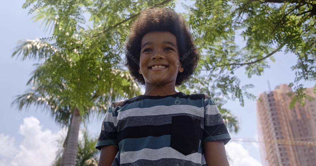 Retrato fofo ao ar livre de um menino afro-americano sorridente.