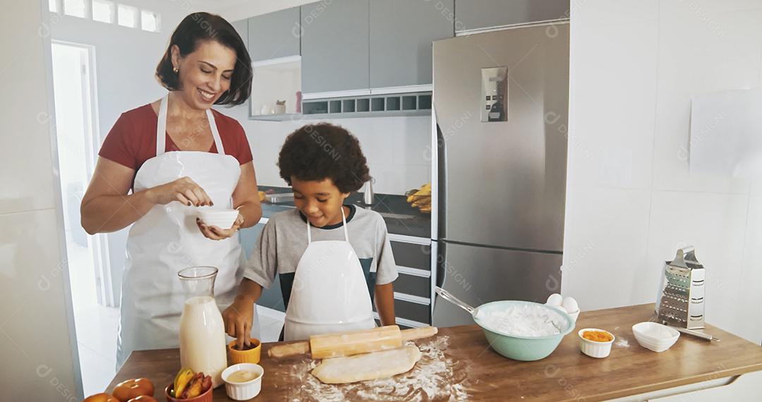 Família jovem cozinhando comida na cozinha. Menina feliz