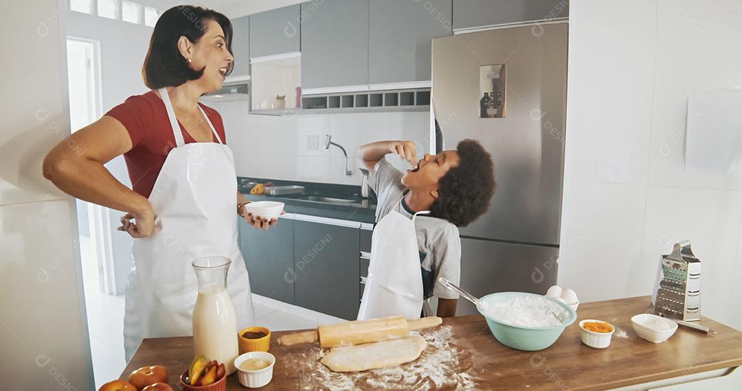 Família jovem cozinhando comida na cozinha. Menina feliz