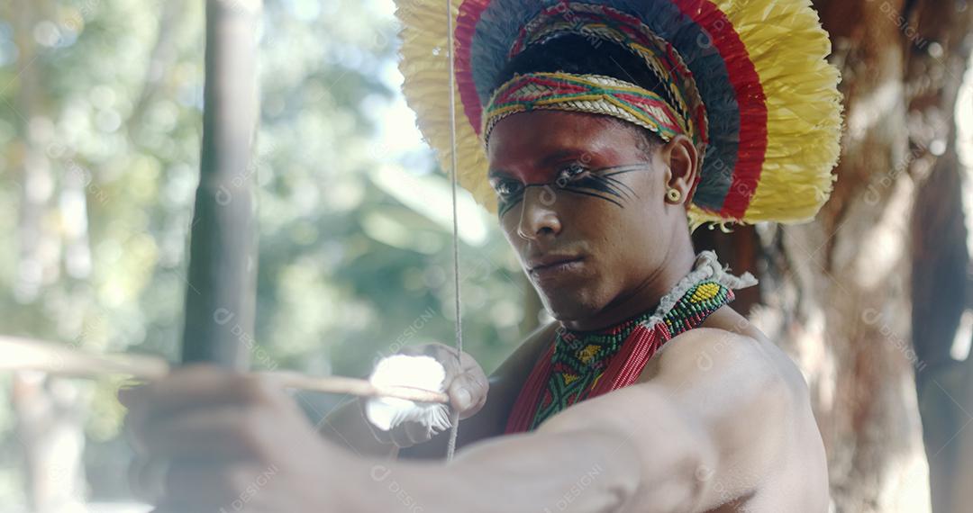 Índio da tribo Pataxó usando um arco e flecha. Da indiano