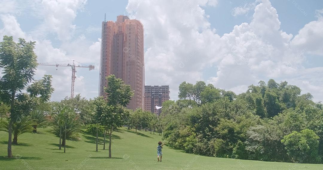 Garoto africano tentando empinar pipa no parque. Atividade de férias