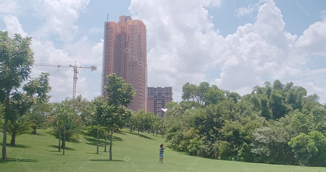 Garoto africano tentando empinar pipa no parque. Atividade de férias