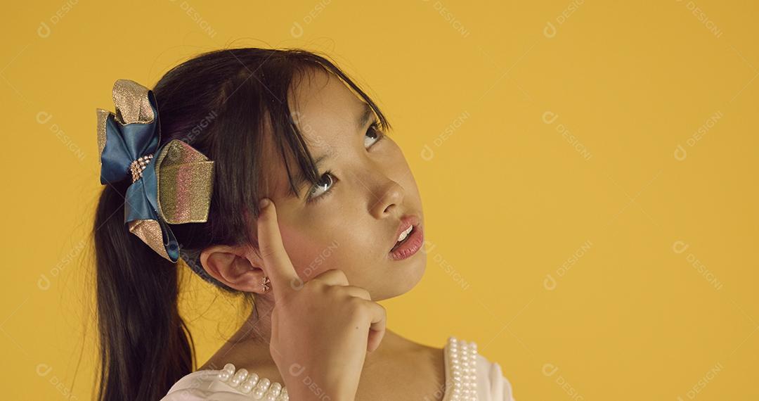 Criança asiática tem uma ideia. Criança japonesa apontando para a cabeça