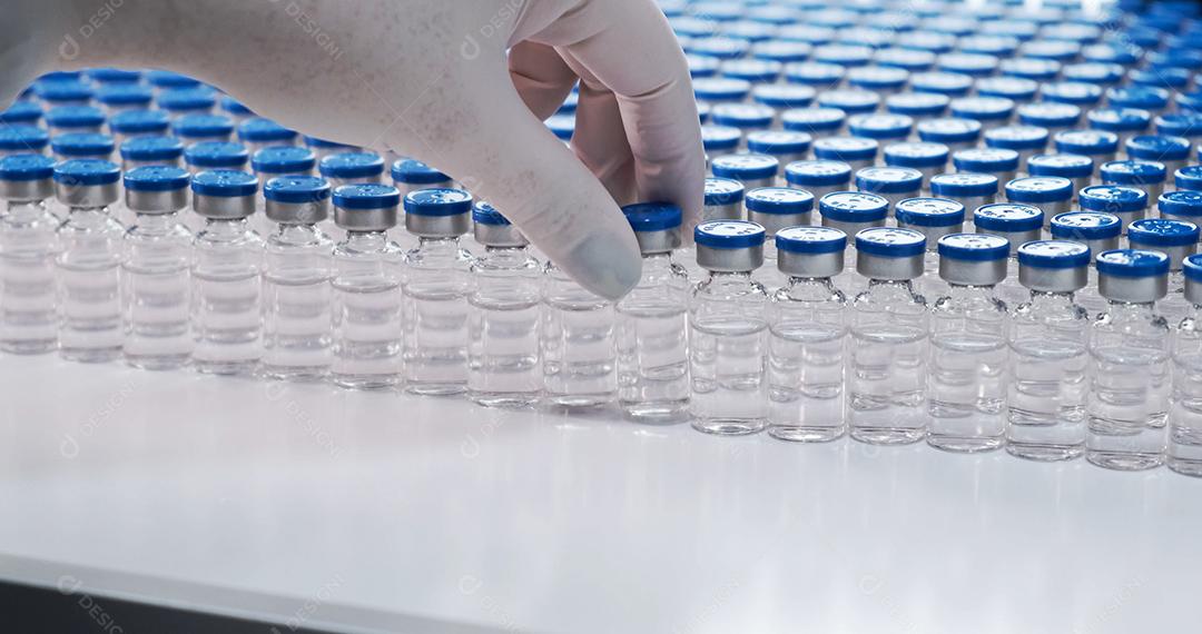 Mão de cientista segurando frasco com vidros de laboratório e tubo de ensaio