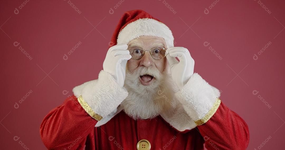 Papai Noel em óculos está olhando para a câmera e sorrindo