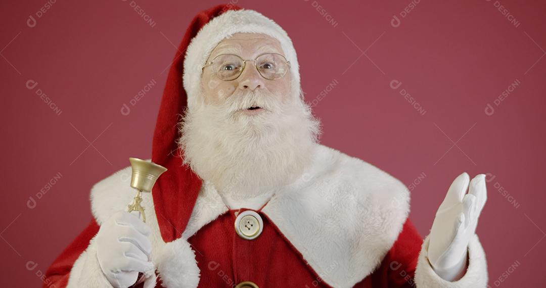 Papai Noel tocando um pequeno sino.