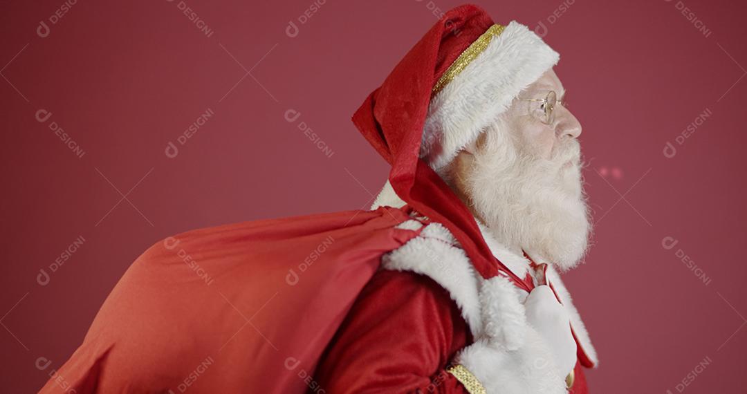 Papai Noel de verdade com fundo vermelho, usando óculos, luvas
