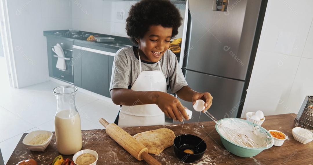 Família jovem cozinhar comida na cozinha. Menina feliz com a mãe misturando a massa. Mãe e filho preparando a massa