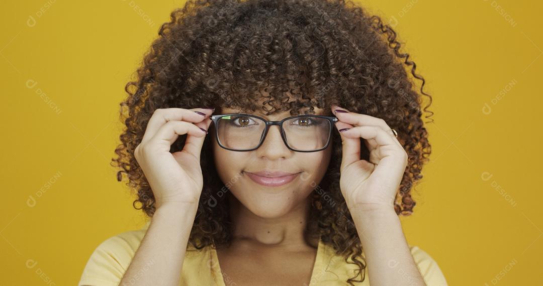 Jovem mulher com cabelo encaracolado feliz com seus óculos. Conceito de cuidados com os olhos.