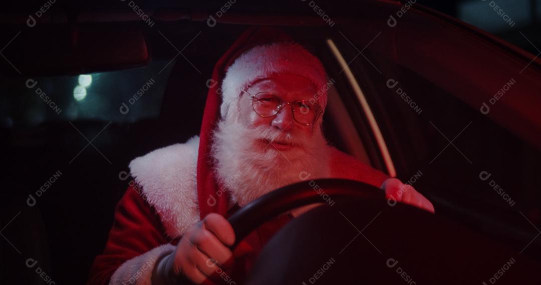 Papai Noel irritado em carro preso no trânsito.