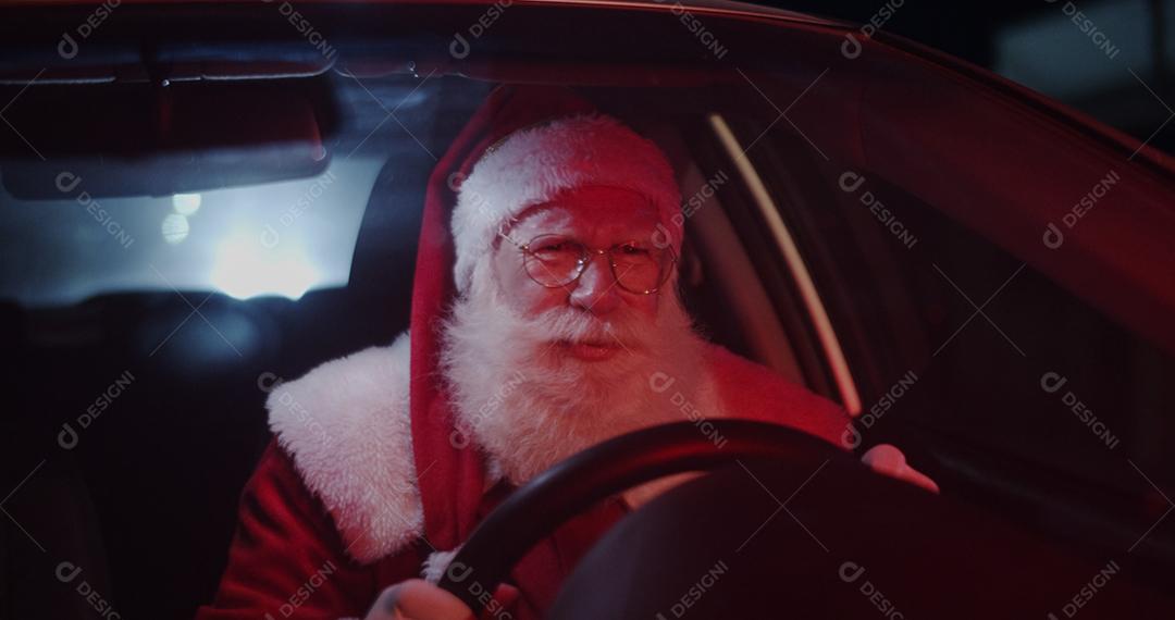 Papai Noel irritado em carro preso no trânsito.