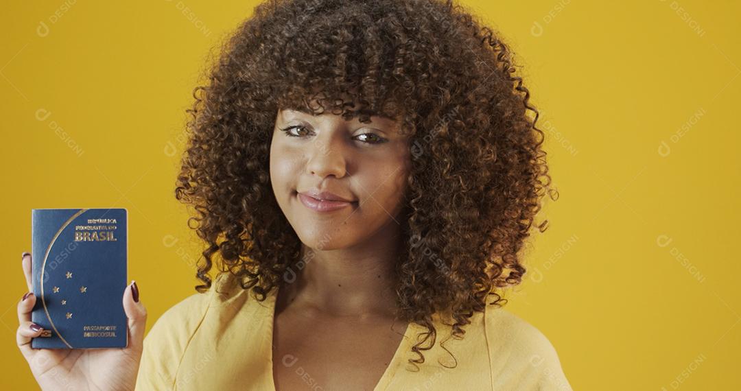 Linda garota de cabelos cacheados em viagens. Próxima viagem. Garota segurando passaporte brasileiro.