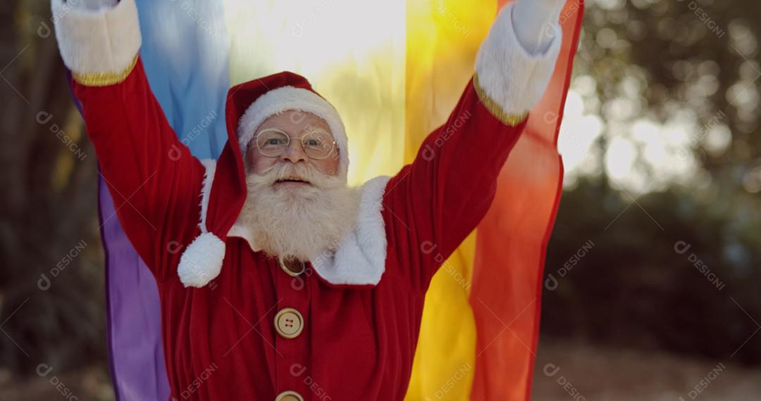 Papai Noel cobrindo com bandeira do orgulho lgbt. Sozinho. Um. Mantendo o punho erguido, cobrindo a bandeira LGBT