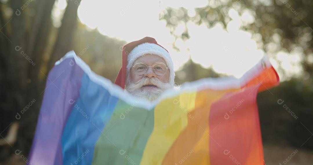 Papai Noel cobrindo com bandeira do orgulho lgbt. Sozinho. Um. Mantendo o punho erguido, cobrindo a bandeira LGBT