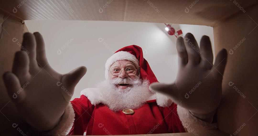 Papai Noel abrindo a caixa com seu pedido recebido pelo correio