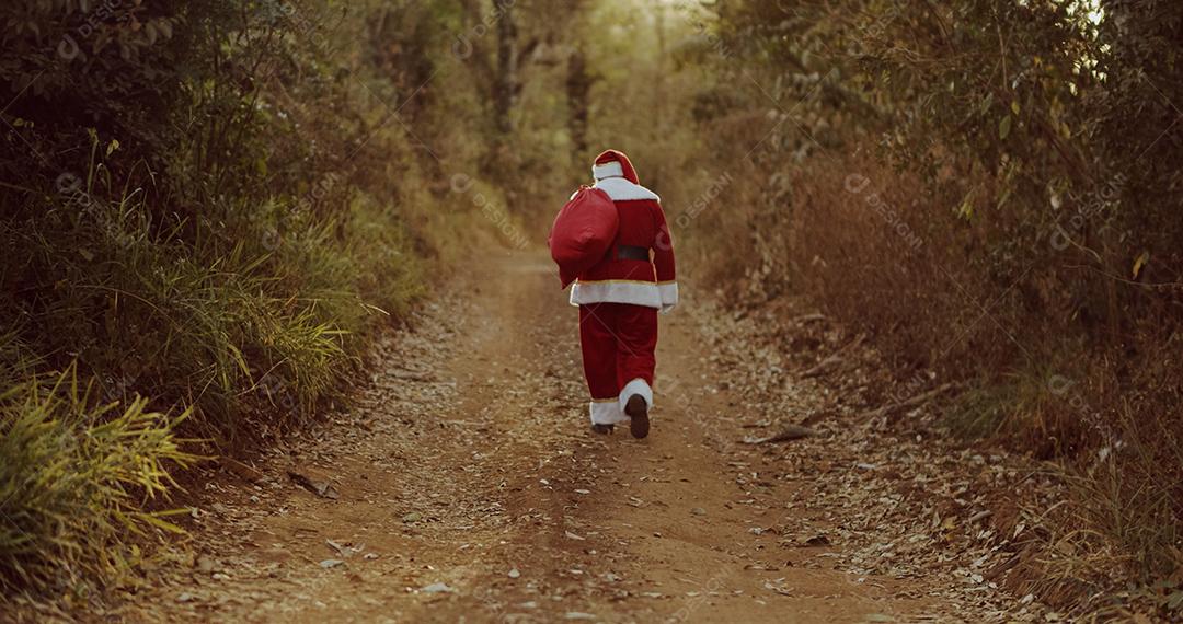 Papai Noel andando por uma estrada de terra, procurando um endereço