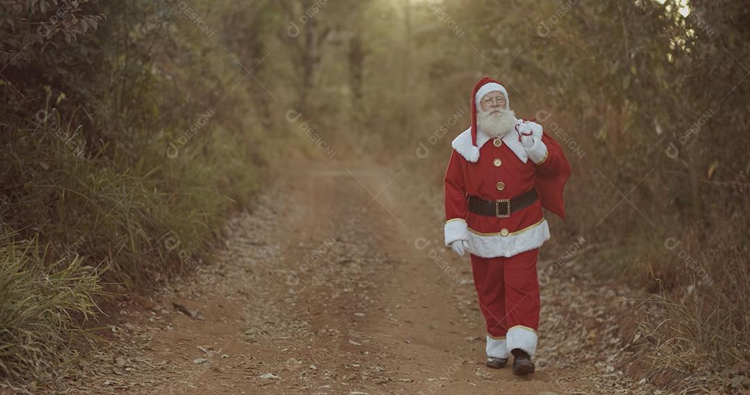 Papai Noel andando por uma estrada de terra, procurando um endereço