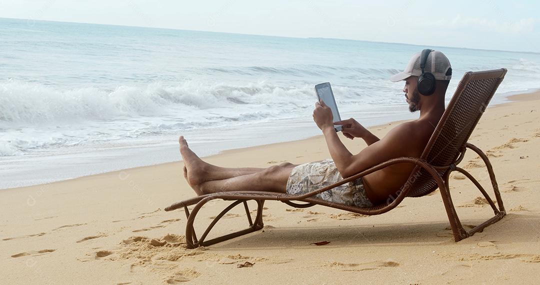 Homem fazendo uma chamada de vídeo nas férias de verão. homem latino-americano