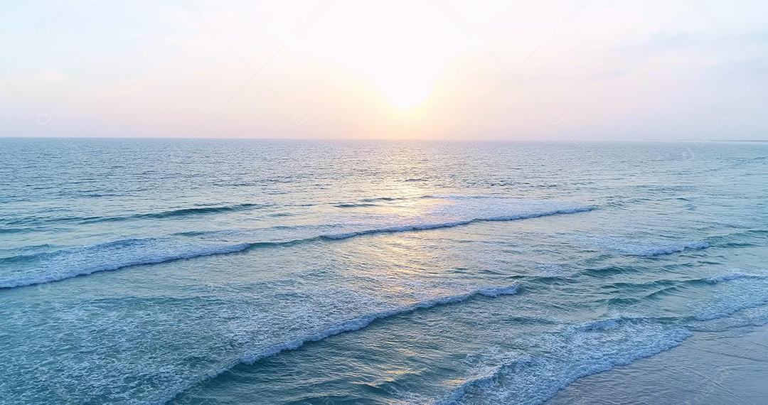 Ondas suaves com espuma do oceano no fundo da praia
