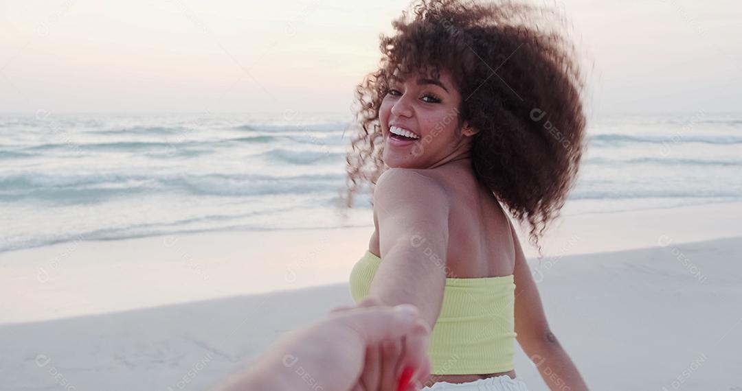 Garota segurando a mão masculina e correndo na praia tropical exótica