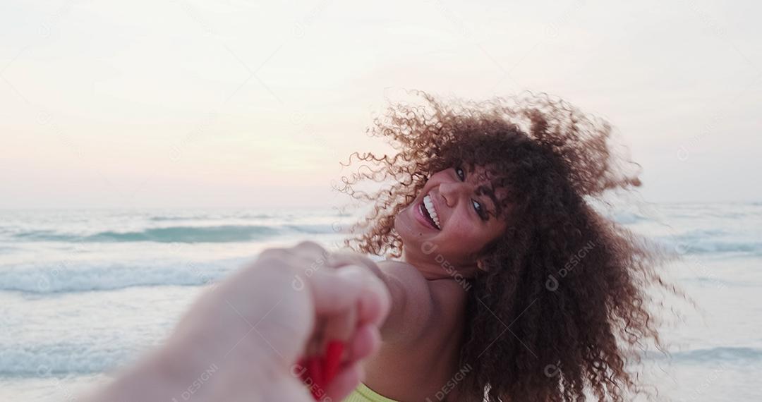 Garota segurando a mão masculina e correndo na praia tropical exótica