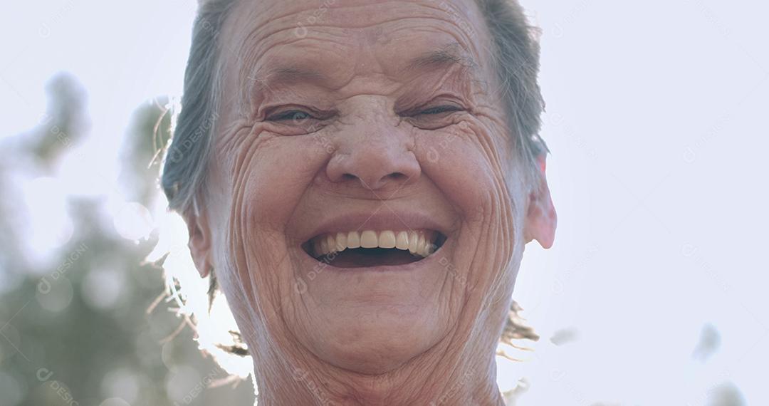 Retrato de uma linda mulher idosa no parque de verão sorrindo.