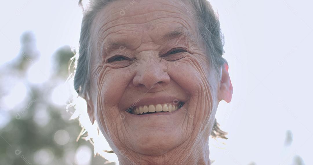 Retrato de uma linda mulher idosa no parque de verão sorrindo.