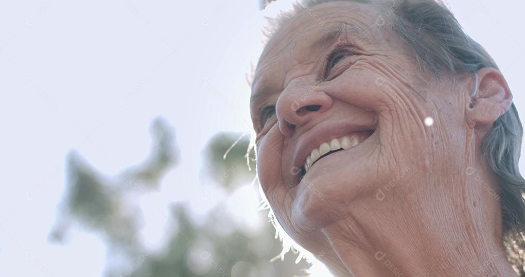 Retrato de uma adorável idosa no parque de verão olhando
