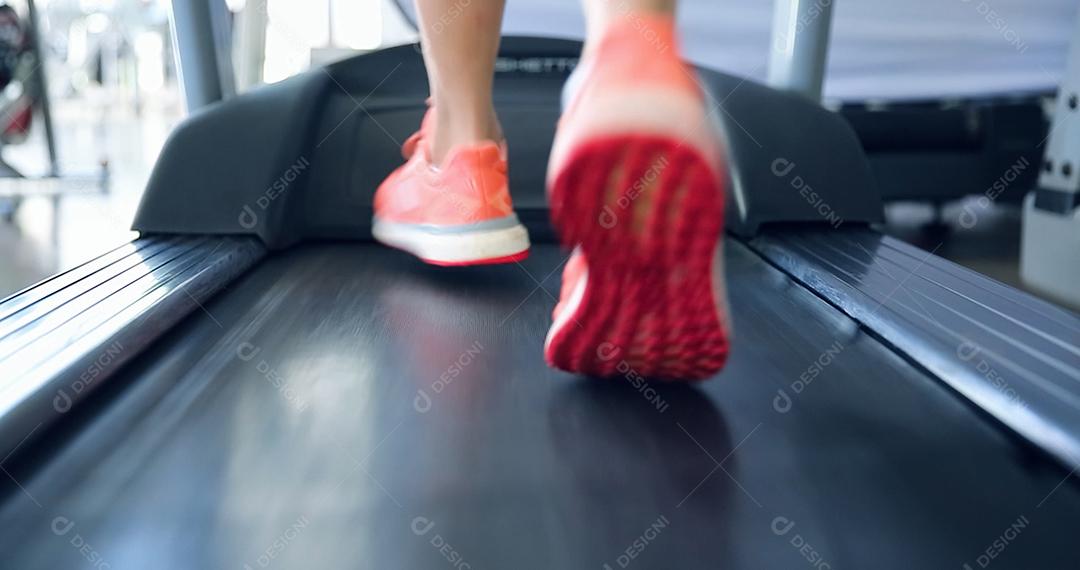 Feche nos pés do atleta malhando na academia. Fazendo cardio