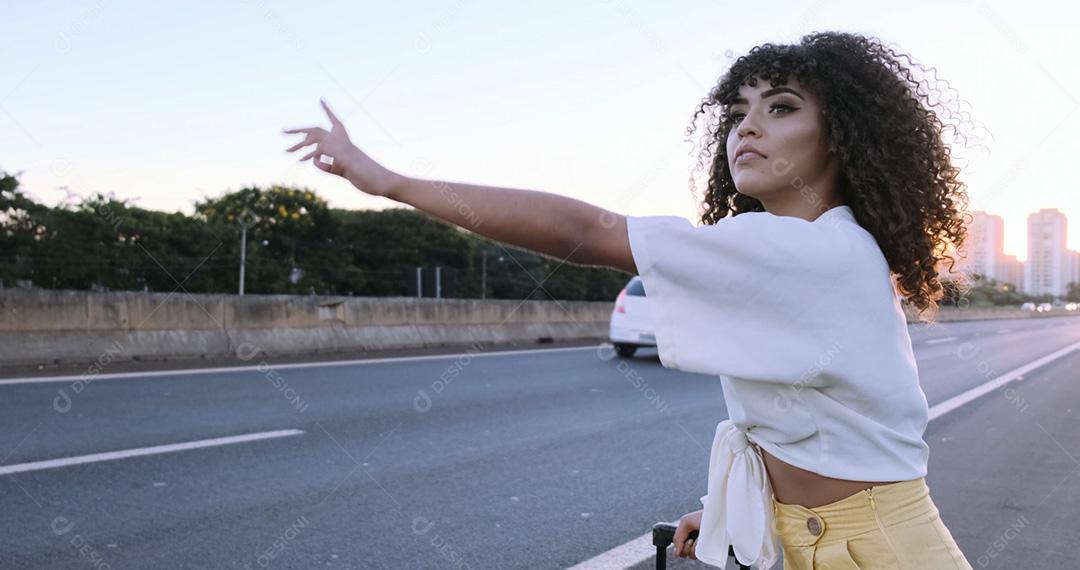 Linda mulher afro-americana mostrando os polegares na zona rural pede carona. menina brasileira