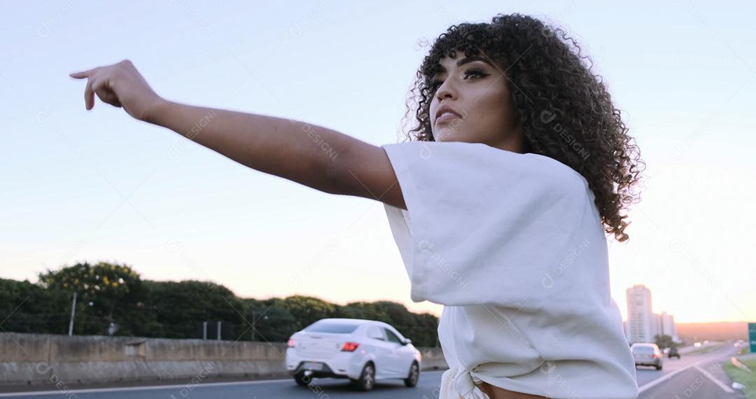 Linda mulher afro-americana mostrando os polegares na zona rural pede carona. menina brasileira