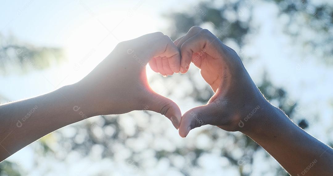 Casal irreconhecível pegando sol com seu coração em forma