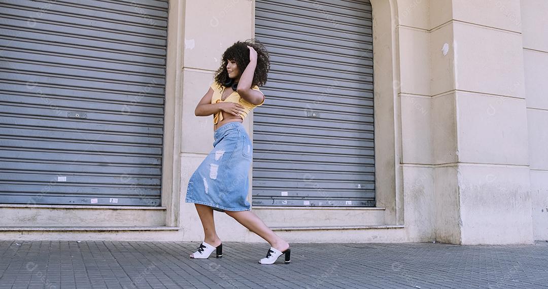 Dançarina de estilo moderno com afro na cabeça dançando na rua