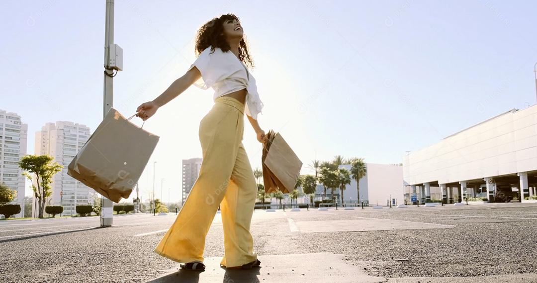 Mulher latina feliz com sacolas de compras. Legal jovem negra andando com sacolas de compras