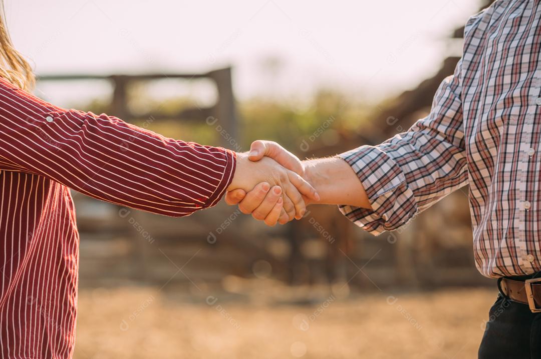 Agricultores latinos homem e mulher apertando as mãos. Agricultores fechando negócios