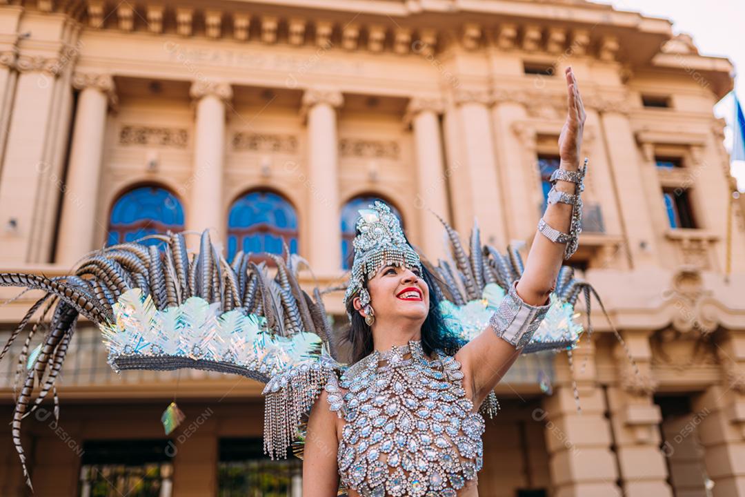 Linda mulher brasileira vestindo fantasia de carnaval colorida e bandeira do Brasil durante o desfile de rua de carnaval na cidade.