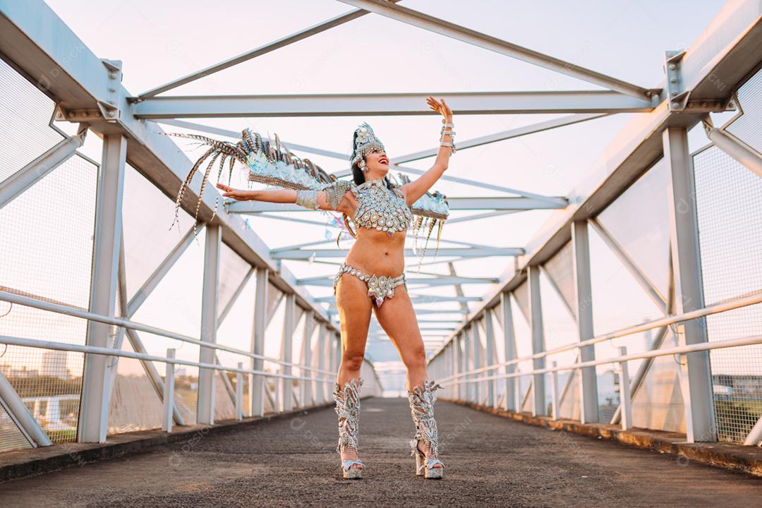 Linda mulher brasileira vestindo fantasia de carnaval colorida e sorrindo durante o desfile de rua de carnaval na cidade.