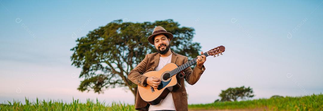 Ao ar livre de um jovem latino-americano tocando violão. músico brasileiro.