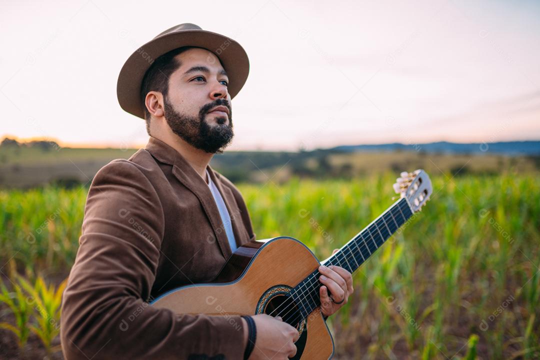 Ao ar livre de um jovem latino-americano tocando violão. músico brasileiro.