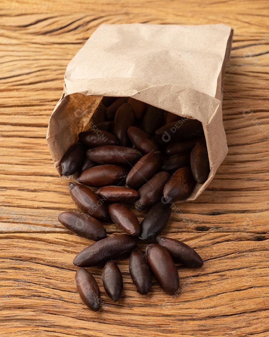 Nozes baru em um saco de papel sobre mesa de madeira