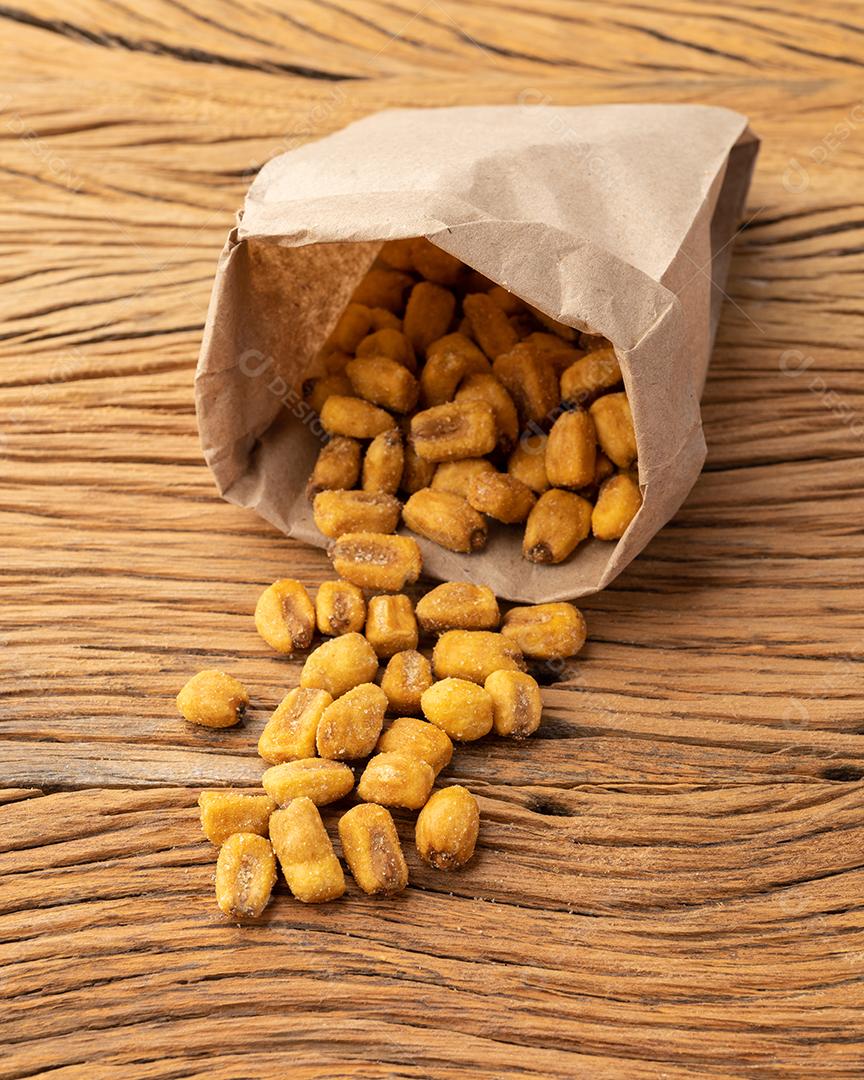 Grãos fritos em um saco de papel sobre a mesa de madeira