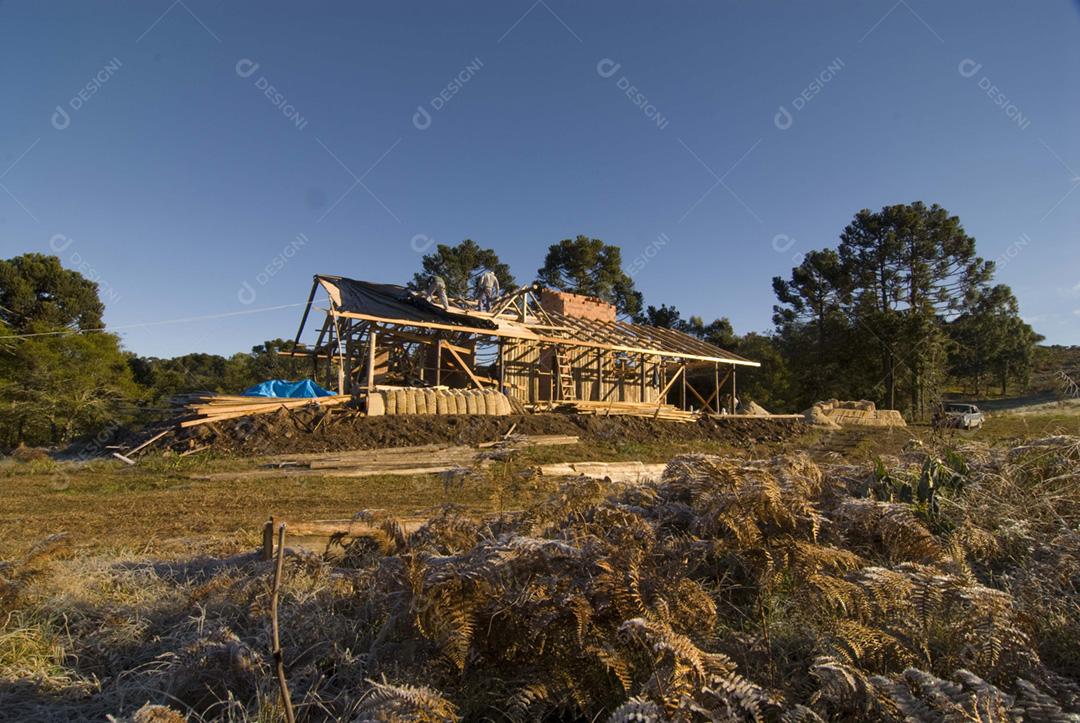 Casa sendo costruida sobre floresta céu azul
