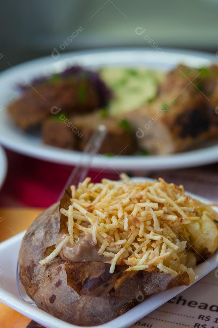 Comida Batata Assada Recheada sobre fundo de madeira