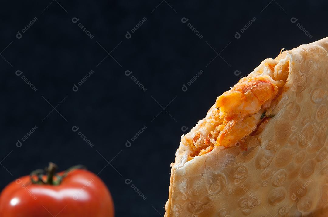 Massa. Pastel de frango em fundo escuro isolado. Pastelaria