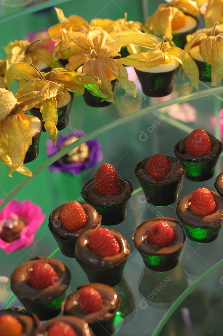 Copinho com doce de chocolate com fruta morango por cima.