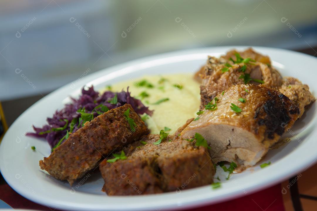 Comida típica da Alemanha com carnes cozidas, salada, pure  de batata e salsinha.