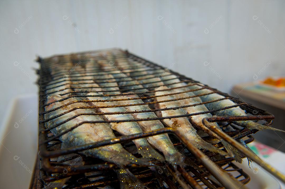 Peixes grelhados prontos para serem assados na churrasqueira.