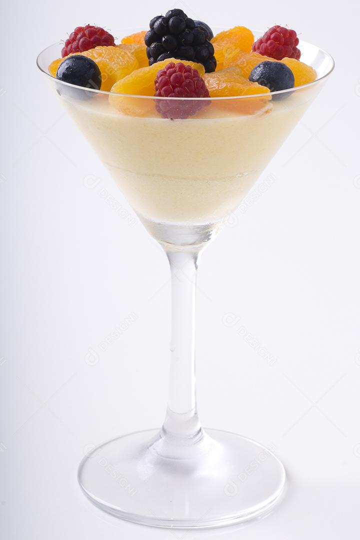 Sorvete gelado com varias frutas sobre taça de vidro. Fundo branco