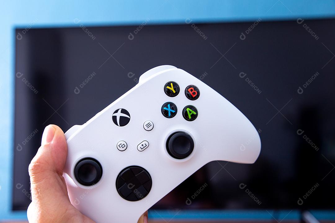 São Paulo, Brasil - 03, 2022: Garota jogando o novo console xbox Series S. Com uma televisão em segundo plano.